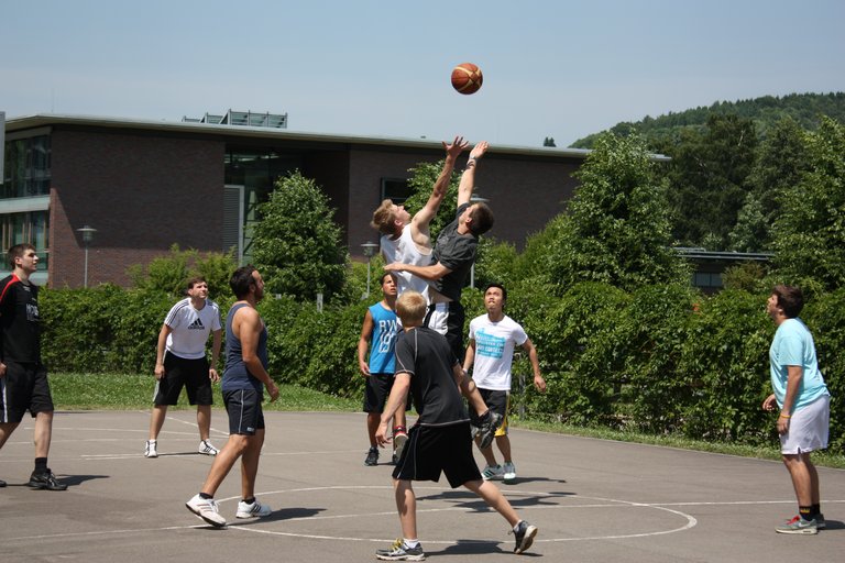 Studierende spielen Basketball auf dem Campus der Hochschule