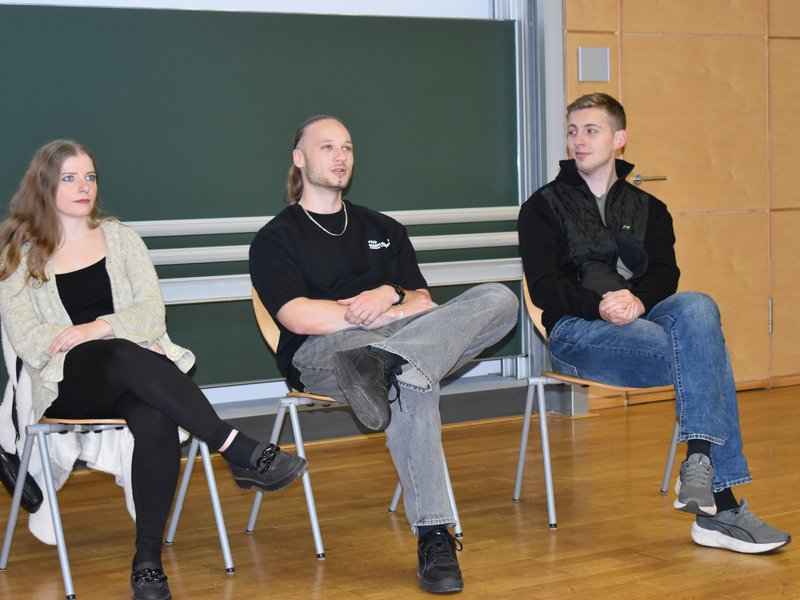Drei Studenten sitzen in einer Reihe