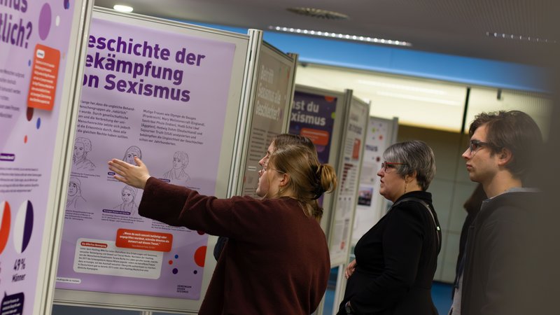 Besucher vor einer Ausstellungstafel