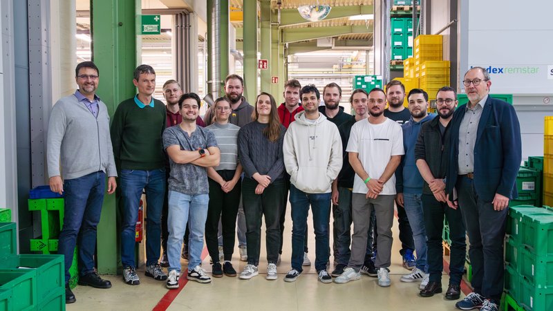 Studierende stehen in einer Gruppe im Unternehmen