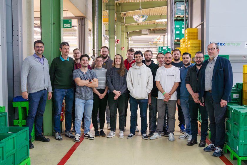 Studierende stehen in einer Gruppe im Unternehmen