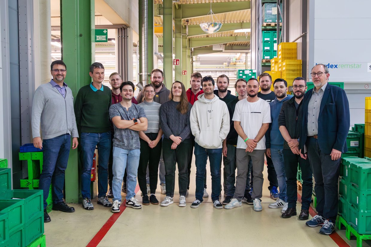 Studierende stehen in einer Gruppe im Unternehmen