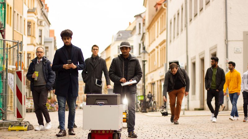 Studenten mit Lieferroboter