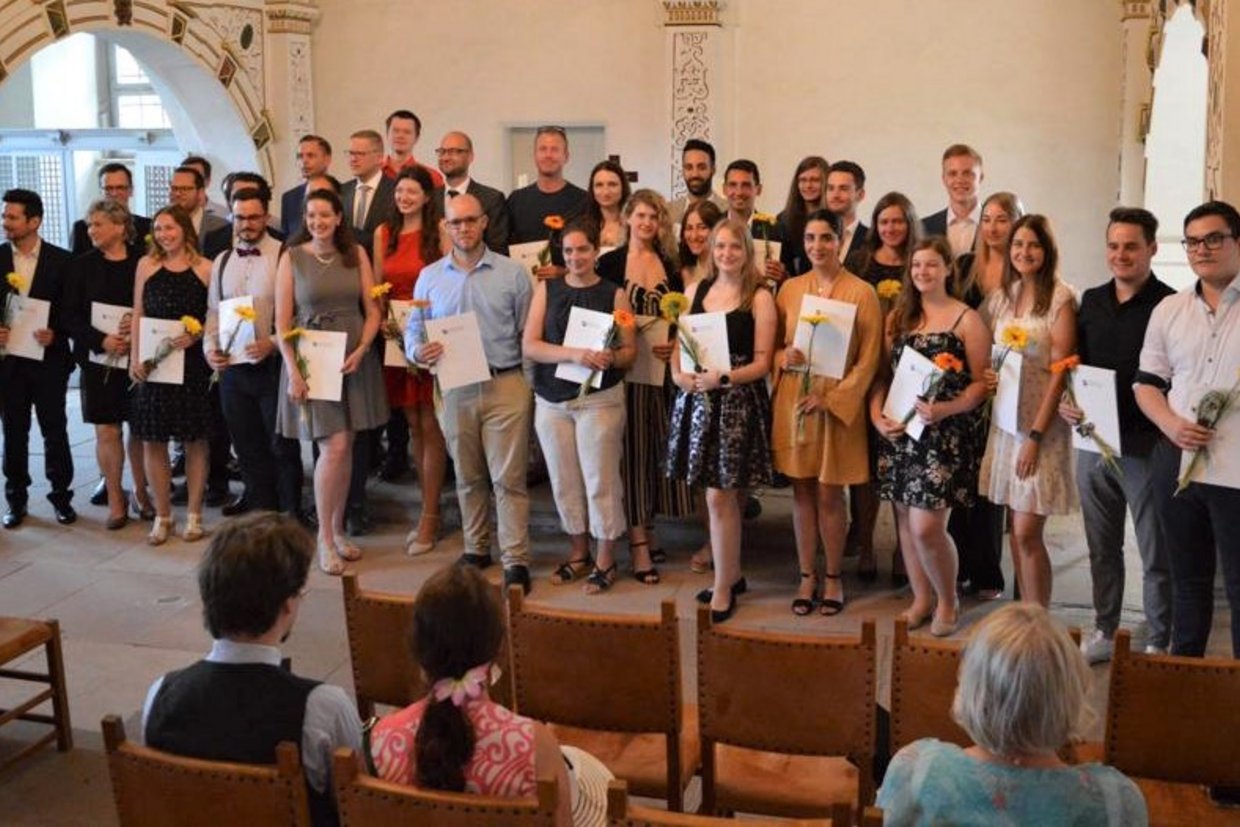 Stolze Absolventen der Fakultät Wirtschaftsrecht mit ihren Zeugnissen in der Schlosskirche von Schloss Wilhelmsburg in Schmalkalden