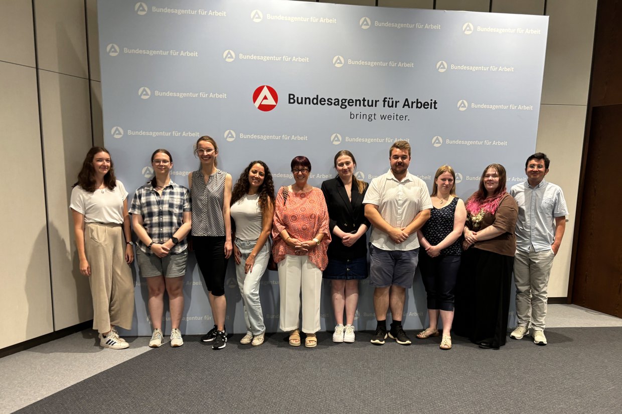 Studierende stehen vor Logo der BA
