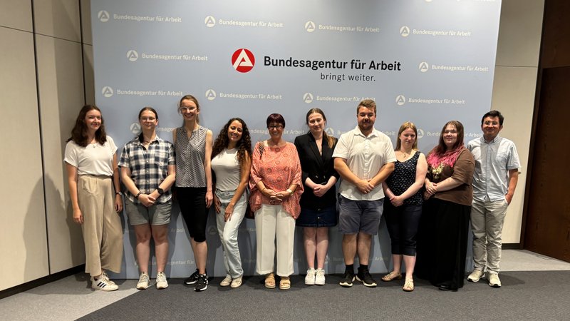Studierende stehen vor Logo der BA