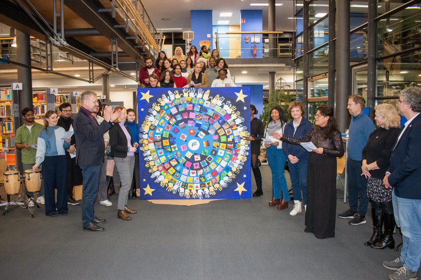 Menschen stehen um ein Bild