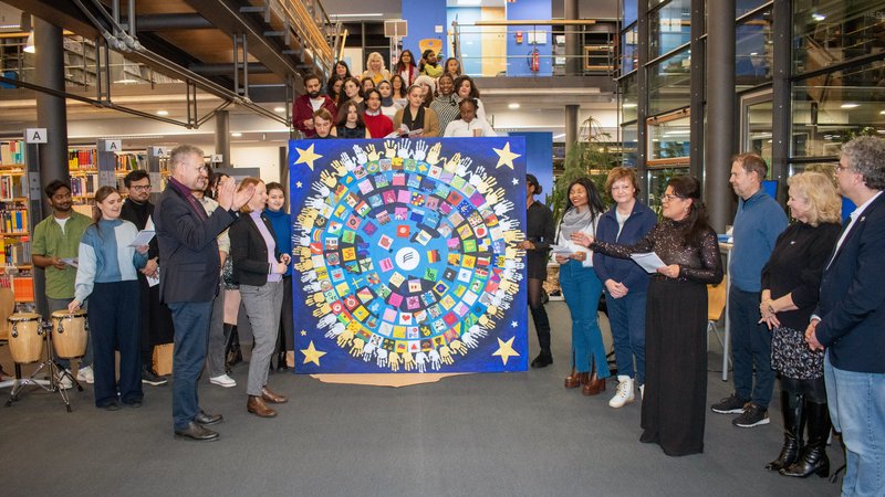 Menschen stehen um ein Bild