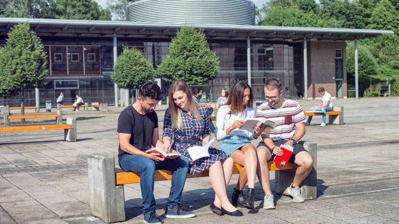 Studierende sitzen vor der Bibliothek der Hochschule Schmalkalden, bald auch Studierende der Wirtschaftspsychologie