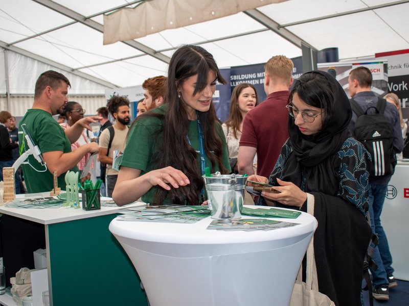 Studentin und Ausstellerin am Tisch