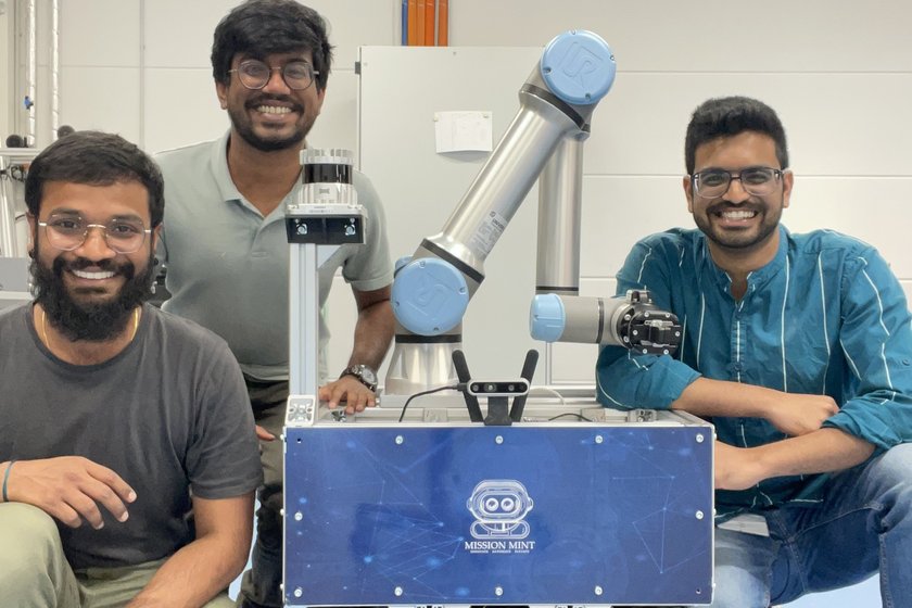 Das Forscherteam um Jayabadhrinath Krushnan (l.) mit dem selbst entwickelten Roboter. Drei indische Männer mit Roboter