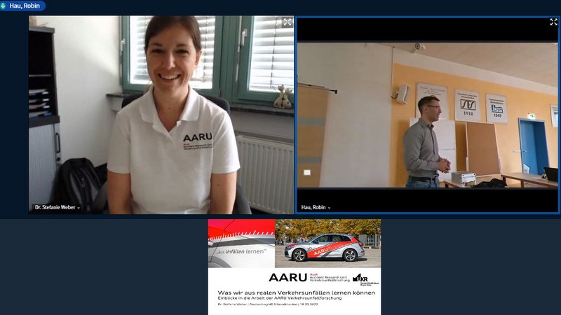Bild 1: Drei Panels aus einer Videokonferenz. Oben links: Dr. Stefanie Weber lacht in die Kamera. Oben rechts: Robin Hau spricht zum Publikum vor Ort. Unten Mitte: Titelfolie mit Audi-Fahrzeug