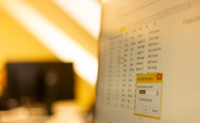 Symbolbild FDM Monitor mit Excel-Liste. sonnendurchflutetes Büro im Hintergrund