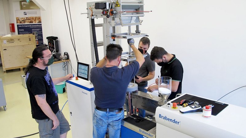 Die Mitarbeiter der Angewandten Kunststofftechnik nehmen die Anlage in Betrieb und testen die Folienblaseinheit.