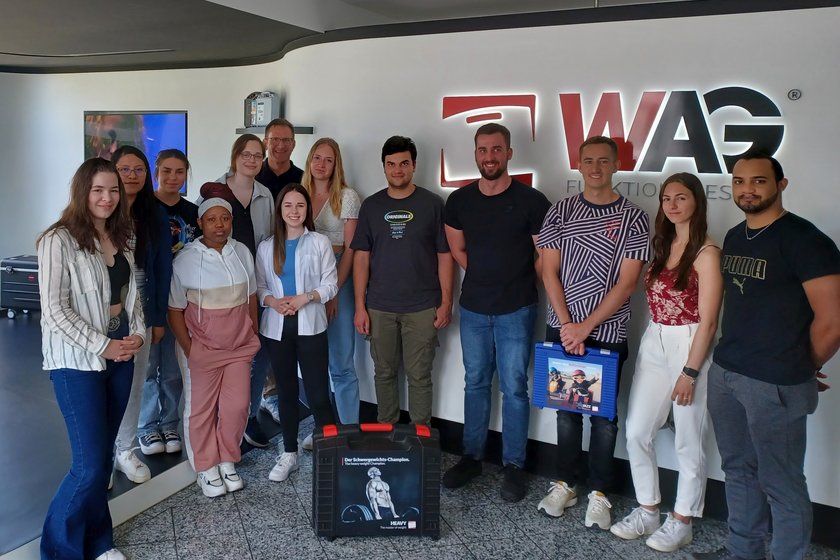 Gruppenfoto-Exkursion Zwölf Studierende und Prof. Dr. Dornieden im Gruppenfoto vor dem WAG-Logo