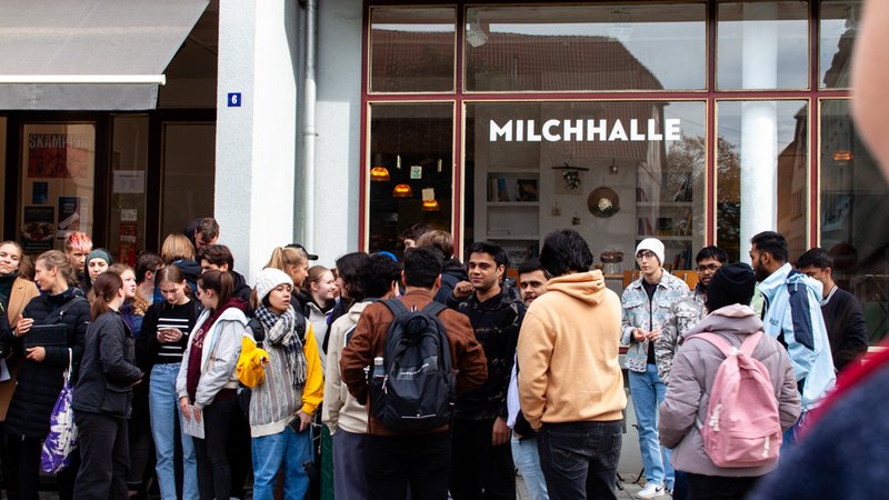 Schüler:innen und Studierenden vor einem Café