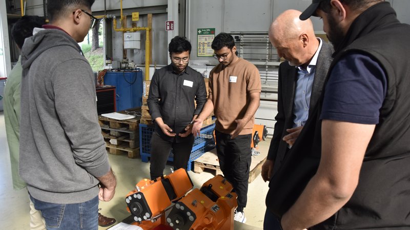 Internationale Studierenden mit Führungskraft in einer Werkshalle