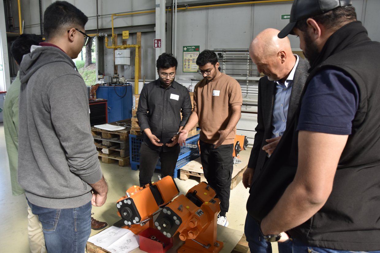 Internationale Studierenden mit Führungskraft in einer Werkshalle