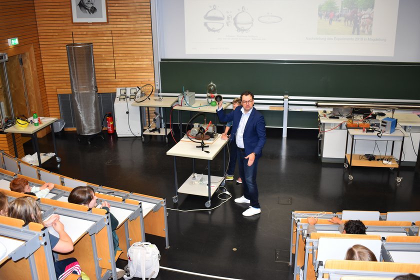 Mann erklärt Kindern Kugeln