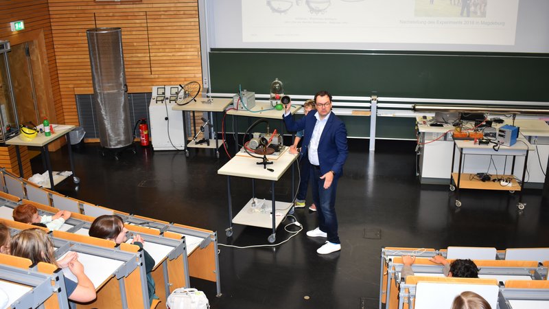 Mann erklärt Kindern Kugeln