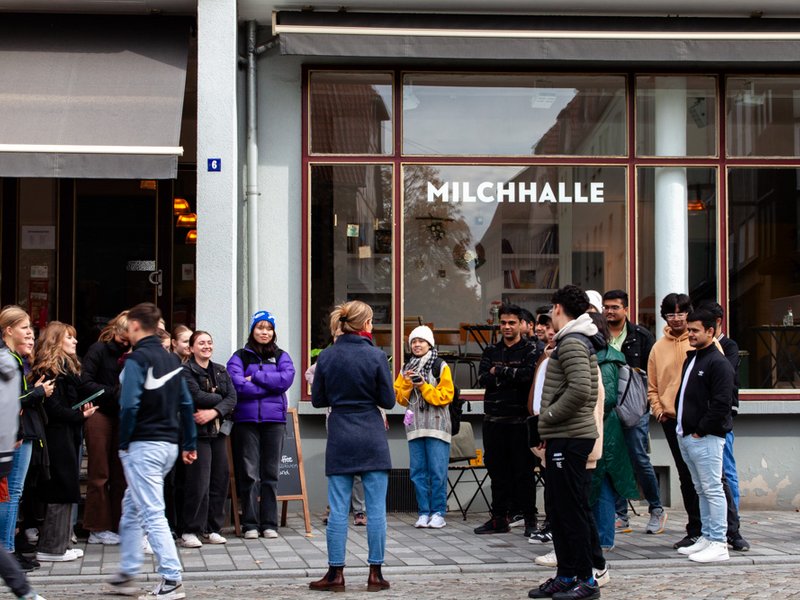 Schüler:innen und Studierenden vor einem Café