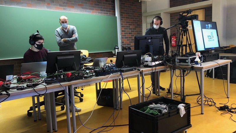 Studierende mit Laptops und Kabeln