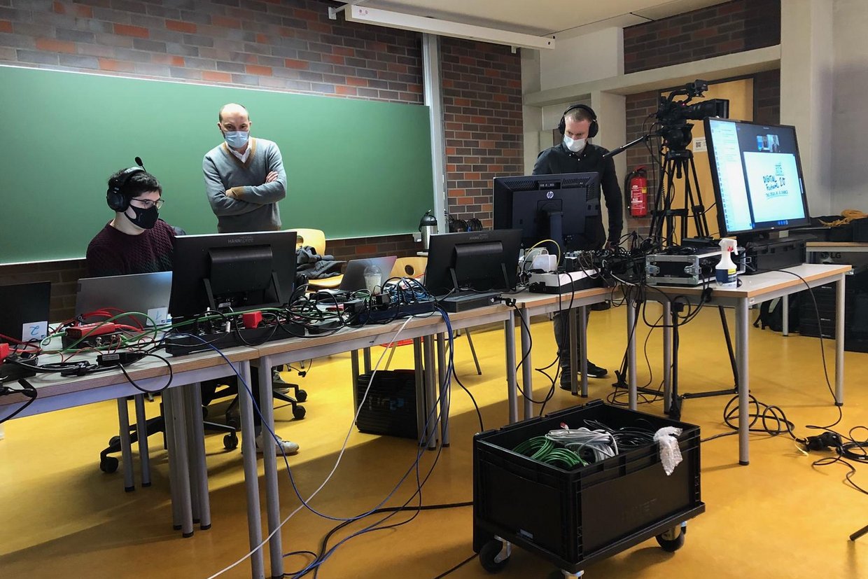 Studierende mit Laptops und Kabeln