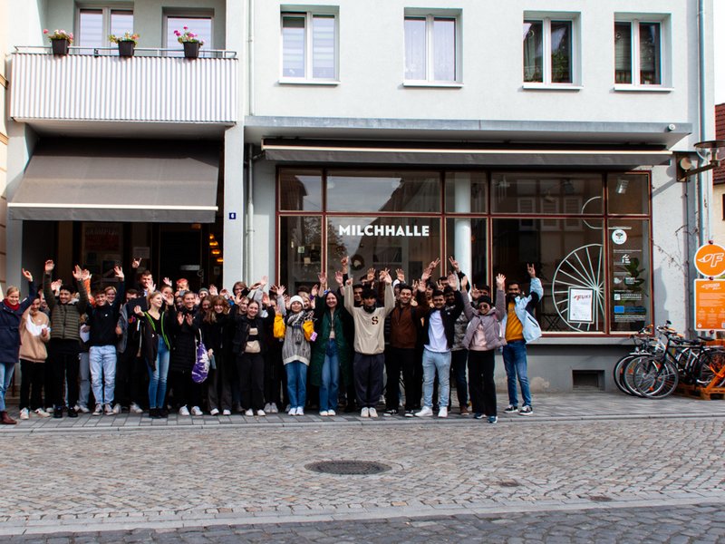 Schüler:innen und Studierenden vor einem Café