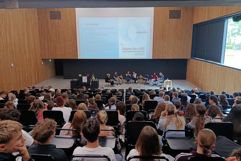 Menschen schauen auf Podium im Hörsaal