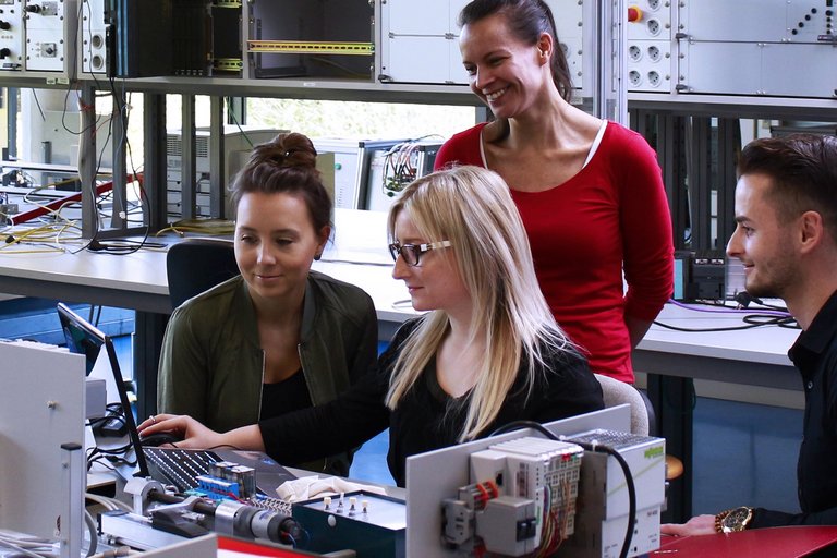 3 Menschen vor einem Laptop