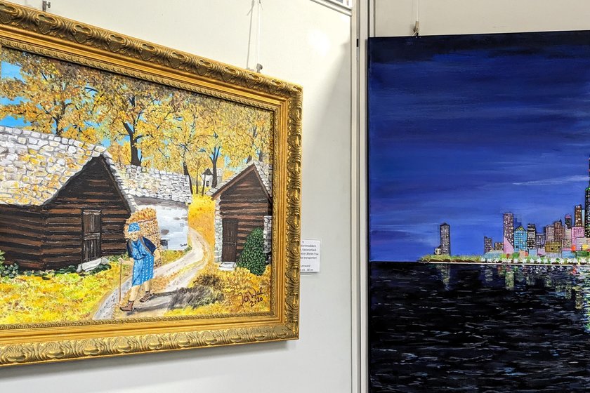 Foto von zwei Gemälden der Ausstellung: Dorf im Herbst und nächtliche Großstadt