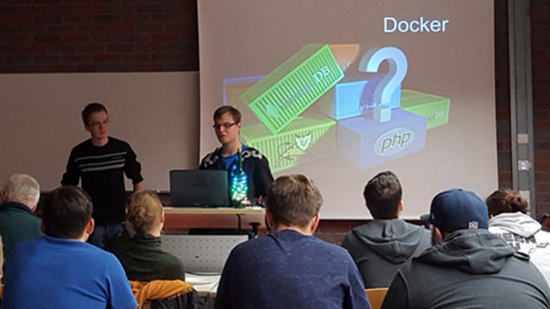 Absolventen der Fakultät Informatik beim Vortrag über Docker