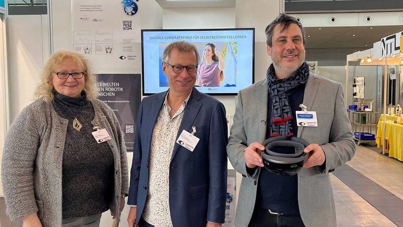 Regina Polster, Kurt Englmeier und Hartmut Seichter vorm Messestand