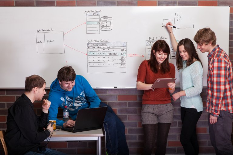 Studierende zeichnen an der Tafel