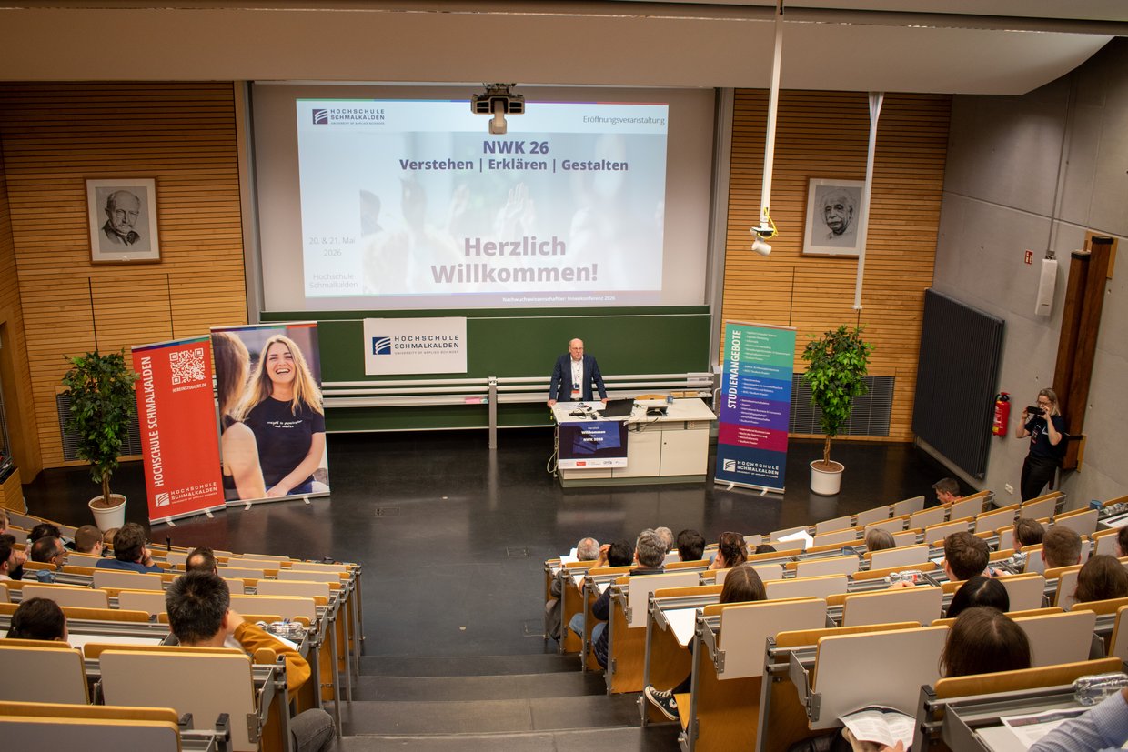 Professor begrüßt Teilnehmer im Hörsaal