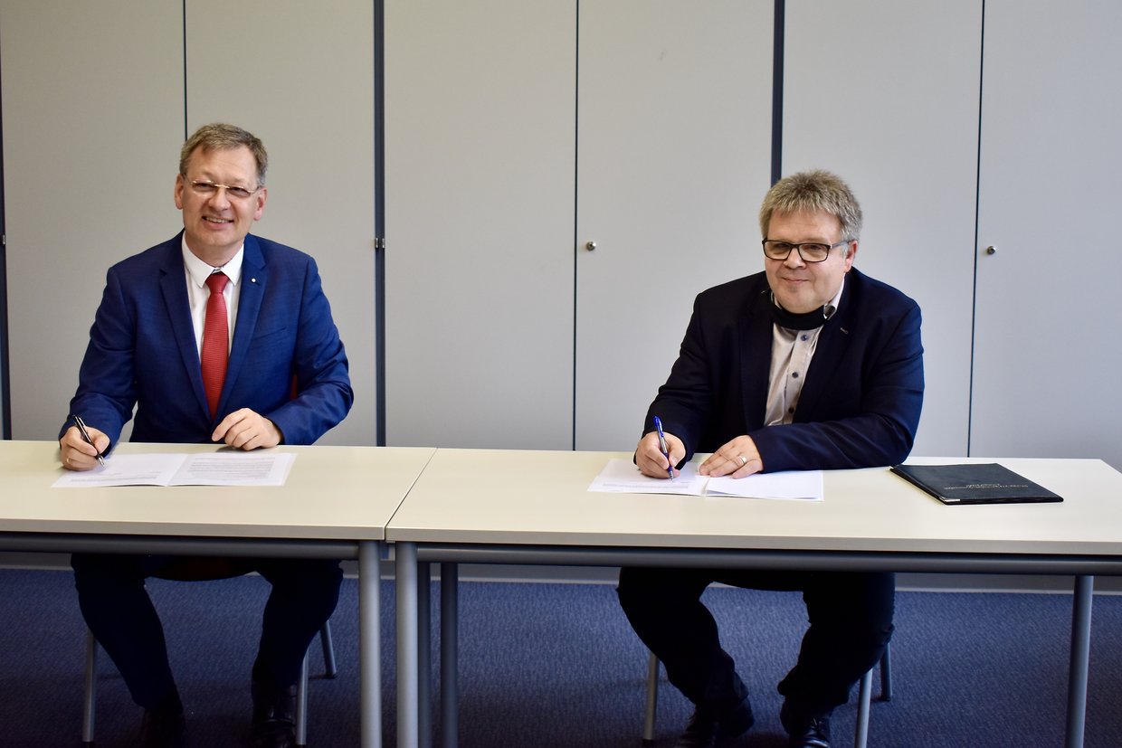 Hochschulpräsident Prof. Gundolf Baier und Schulleiter Jürgen Haaß unterzeichnen den Kooperationsvertrag.