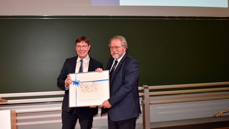 Thomas Kaminski überreicht Prof. Elmar Heinemann ein Bild