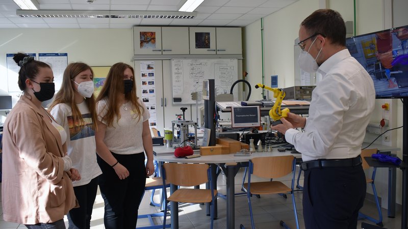 Prof. Frank Schrödel mit drei Schülerinnen im Labor