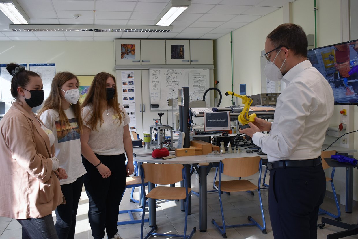 Prof. Frank Schrödel mit drei Schülerinnen im Labor