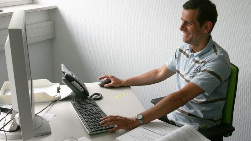 Dr. Tobias Simon an seinem Arbeitsplatz im Büro vor dem PC