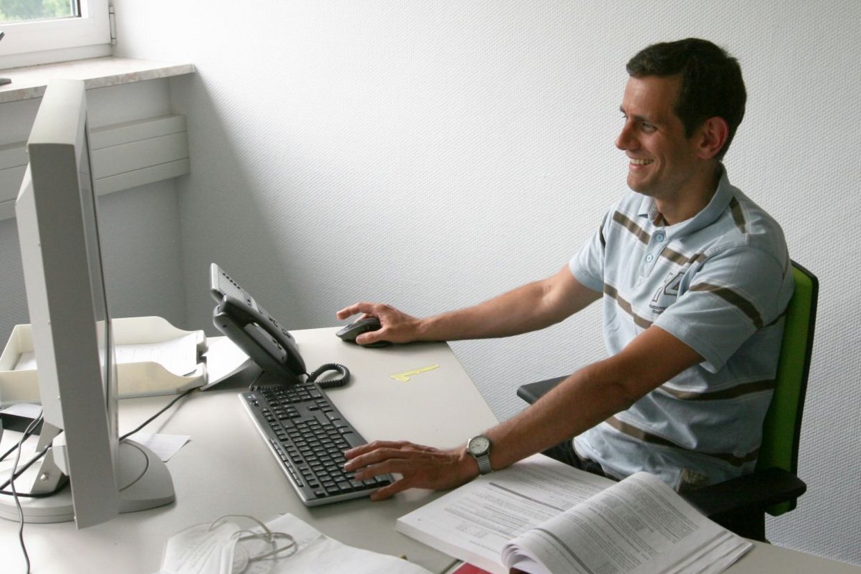 Dr. Tobias Simon an seinem Arbeitsplatz im Büro vor dem PC
