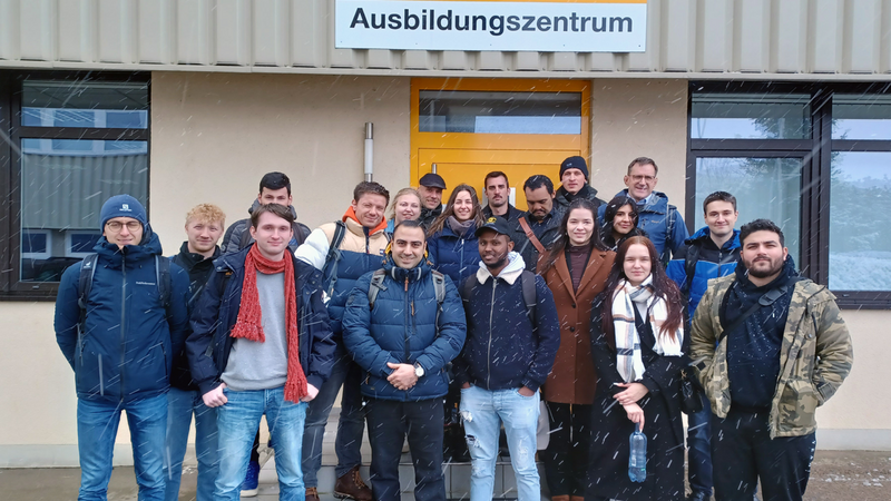 Studierende bei Schneetreibem vor dem Ausbildungszentrum von ContiTech am Standort Waltershausen