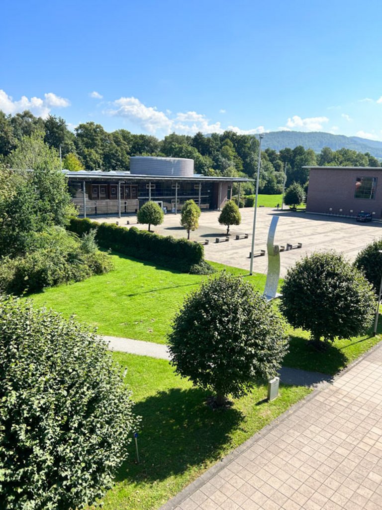 Grüner Campus mit verschiedenen Hochschulgebäuden