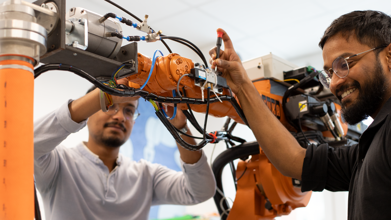 Zwei Studierende am Roboter.